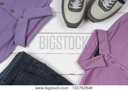 set of men's clothing and shoes on wooden background. Sports T-shirt and sneakers in bright colors. Top view
