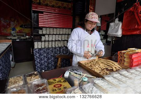 WUZHEN CHINA - MARCH 24: Unidentified Chinese people trade traditional food on March 24 2016 in Wuzhen China. Wuzhen is a historic scenic town located in northern Zhejiang Province China