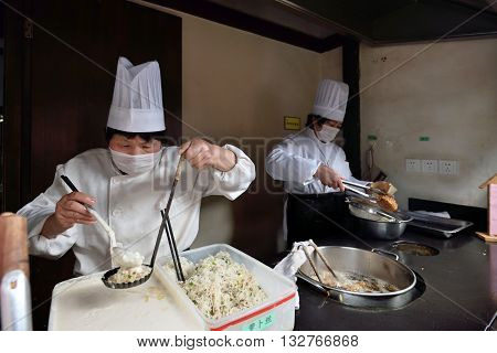 WUZHEN CHINA - MARCH 24: Unidentified Chinese people trade traditional food on March 24 2016 in Wuzhen China. Wuzhen is a historic scenic town located in northern Zhejiang Province China