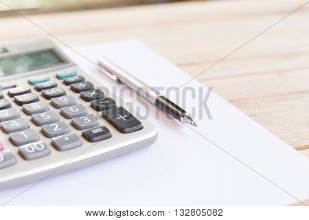 Blank white notebook with pen on wood desk. shallow depth of field