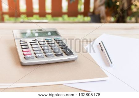 Blank white notebook with pen on wood desk. shallow depth of field
