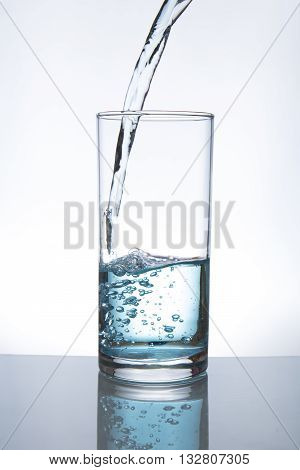 Concept of drinking. Pouring water from into glass