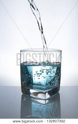 Concept of drinking. Pouring water from into glass