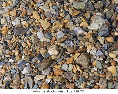 Colored stones background on the bottom of the canyon .