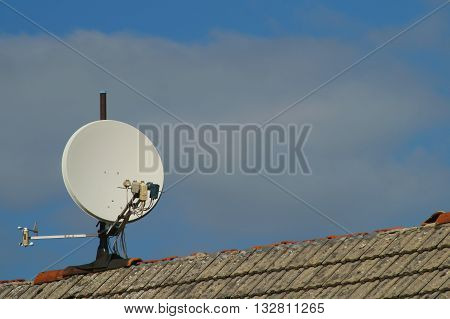 Satellite dish on a roof with defective roof ridge .