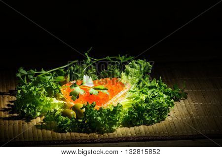 still life with red caviar black bread and fresh herbs