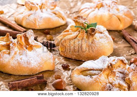 Сoconut puff pastries on parchment paper sprinkled with sugar icing close up