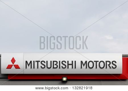 Haderslev, Denmark - May 29, 2015: Mitsubishi Motors Corporation sign on a wall. Mitsubishi Motors Corporation is a multinational automotive manufacturer headquartered in Tokyo, Japan