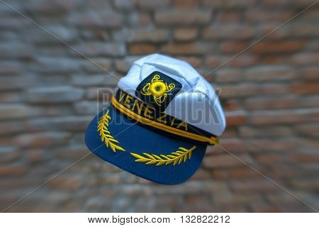 Levitating Venezia navy hat in front of blurred brick wall with zoom effect. Standard souvenir cap from Venice flying in front of brick wall with zoom effect.