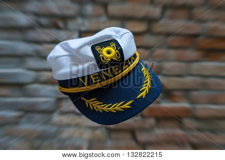Levitating Venezia navy hat in front of blurred brick wall with zoom effect. Standard souvenir cap from Venice flying in front of brick wall with zoom effect.