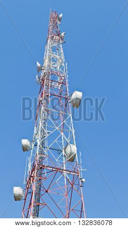 Telecommunication mast with microwave link and TV transmitter antennas over a blue sky.