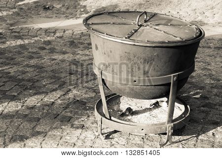 big ancient cauldron from iron or a boiler for cooking with a fire chamber for firewood and coals
