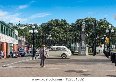 Napier New Zealand - November 19 2014: Elderly man 1930s dressed and vintage motorcar on the Marine Parade in the art deco town of Napier New Zealand. Marine Parade is the main street in Napier.