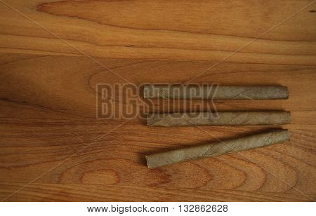 three tobacco for smoke on brown wood background