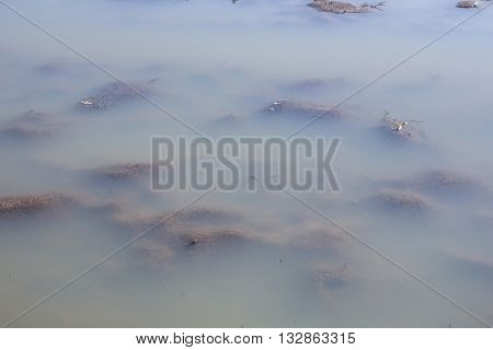 Agriculture plowed mud field under blurry water flood