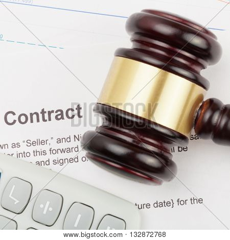 Wooden Judge's Gavel And Calculator Over Contract And Financial Charts