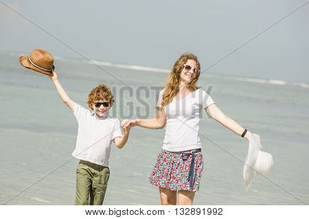 Yound caucasian mother and son having great family time on tropical beach on vacation