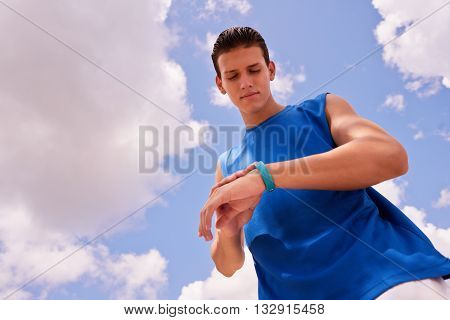 Young people doing sport activities man runner jogging using fit watch. Concept of leisure health recreation fitness lifestyle exercising training workout