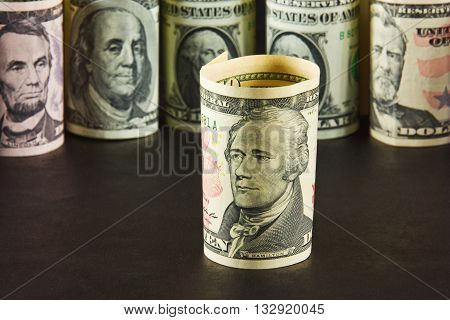 President with ten dollar bills on a background of presidents from other denominations