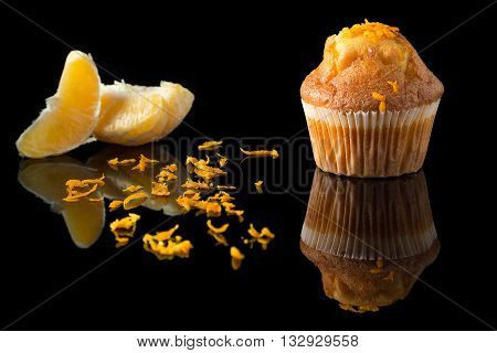 orange muffin with orange on black with reflection