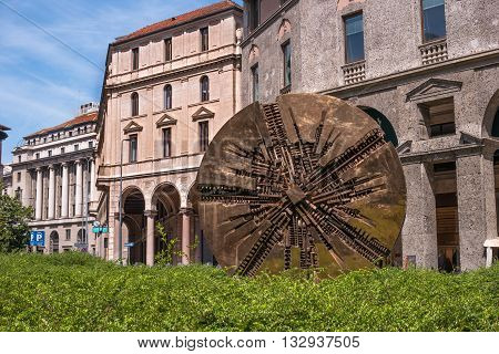 Milan Italy - May 25 2016: Disco abstract bronze circular sculpture with contemporary value by Arnaldo Pomodoro on Piazza Meda created in 1980