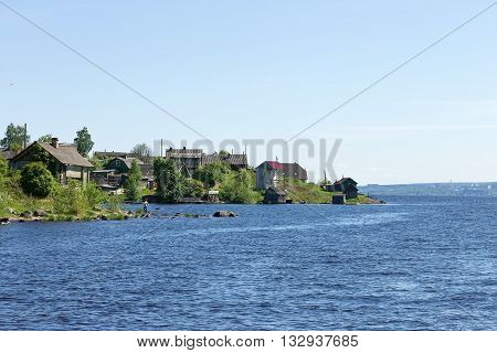 Rural landscape with wooden houses by the lake Onega in the Russian village