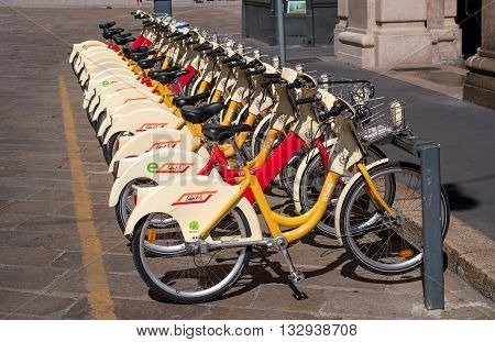 Milan Italy - May 25 2016: yellow BikeMi bicycles for rent in a parking spot. Parking near the Duomo.