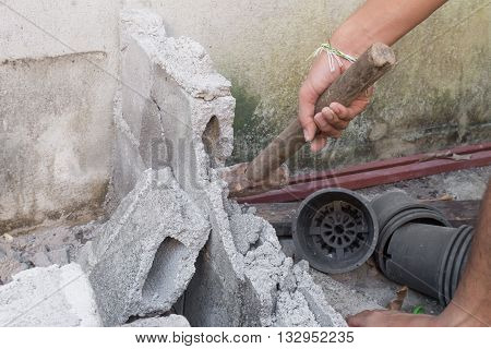 hammer in hand breaking brick wal : young power use Hammer smash a brick wall In construction : select focus Hammer Blur blurred background.