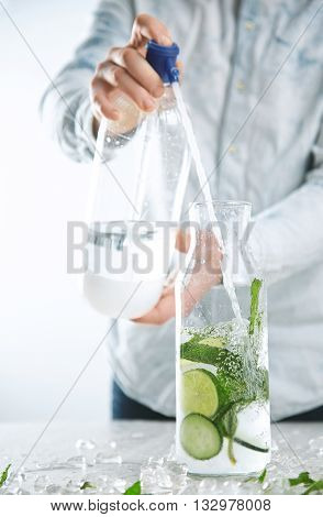 Bartender Pours Sparkling Water From Soda Syphon To Vintage Bottle With Ice Limes Mint And Cucumber