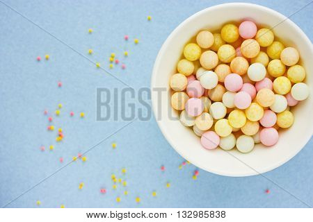 Confectionery food background beautiful sugar bubble sprinkle mix on blue background selective focus blank space for text top view