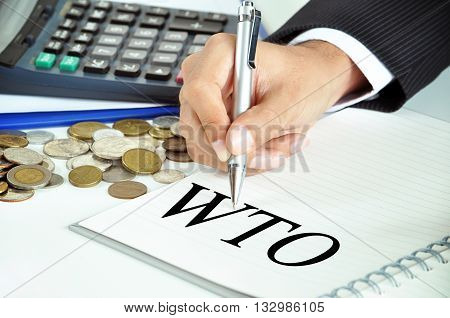 Businessman Hand With Pen Pointing To Wto (or World Trade Organization) On The Paper