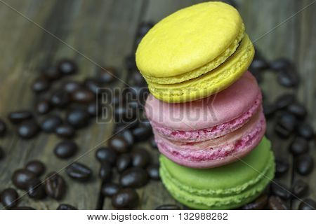 colourful french macaroons and coffee bean on wooden table