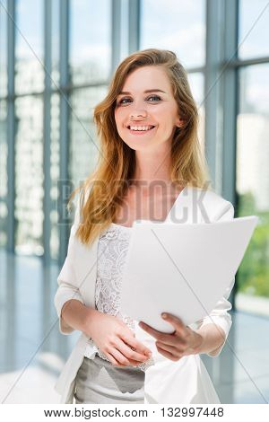 Businesswoman hold some documents against a big window