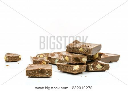 Stack Of Chocolate Pieces With Nuts In Close-up And Isolated On White Background With Copy Space Pla
