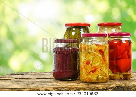 Composite Image Of Jars With Variety Of Homemade Pickled Vegetables On A Wooden Vintage Table And On