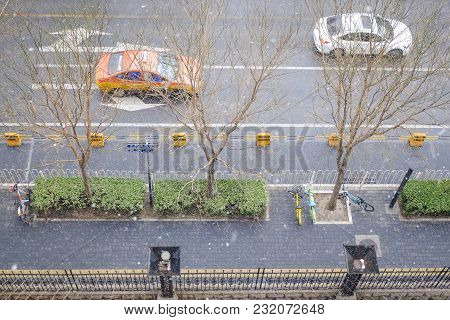 Aerial View Of A Walkway And Two Cars On A Road During Snowy Day. Rare Snowy Day In Chaoyang Distric