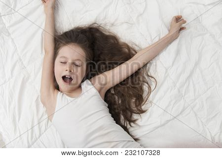 Cute Smiling Little Girl Woke Up In White Bed. Morning In Wekeend. Flat Lay.