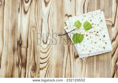 An Overhead Photo Of Matzah Or Matza Pieces And A Small Spring Fresh Linden Tree Branch. Matzah On T