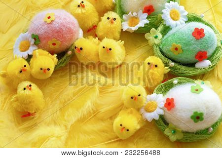 Baby Yellow Easter Toys Chicks And Eggs On A Background Of Feathers. Festive Greeting Card