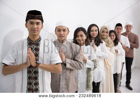 Group Of Muslim Asian Men And Women Smiling And Greeting. Embracing Each Other During Eid Mubarak Ce