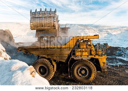 Large Quarry Dump Truck. Loading The Rock In The Dumper. Loading Coal Into Body Work Truck. Mining T
