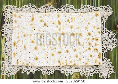 An Overhead Photo Of Matzah Or Matza Piece On The Lace Doily. Matzah On The Wooden Table For The Jew