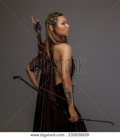 Beautiful Elf Woman With Bow In Her Hand. Isolated On Gray.