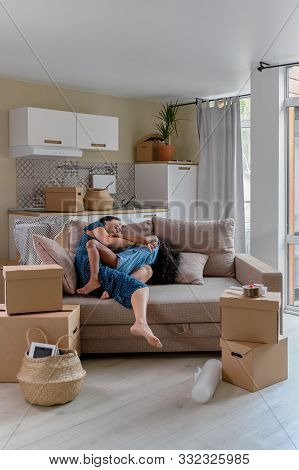 Mom And Daughter Multiraces Move To A New Apartment. Have Fun Jumping And Playing On Sofa.