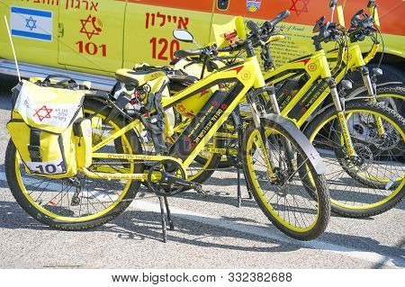 Yellow Car Ambulance And Ambulance Bicycles Magen David Adom With Text And Logoon The Street In Tel 