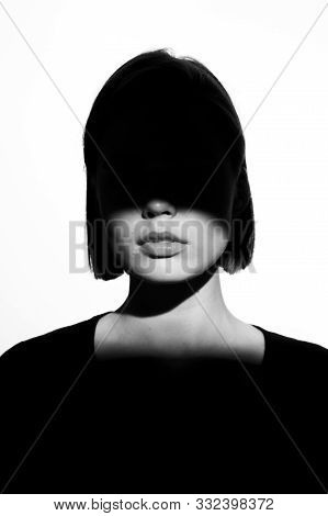 Fashionable Beauty Portrait. Black Silhouette On White Background. Girl With A Spot Of Light On Her 