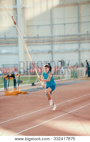 Pole Vaulting Indoors - Young Man In Blue Shirt Running Up Before Jumping With A Pole