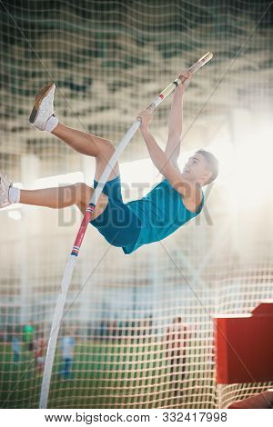 Pole Vaulting Indoors - Young Fit Man Jumping Leaning On The Pole - Sport Stadium