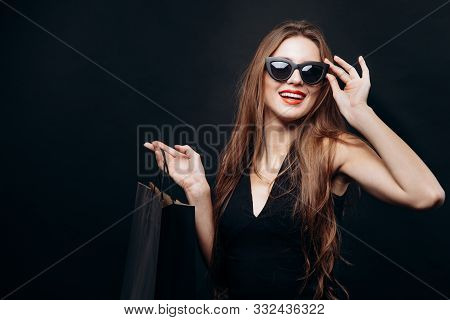 Young Satisfied Trendy Customer Adjusting Sunglasses And Looking Ahead