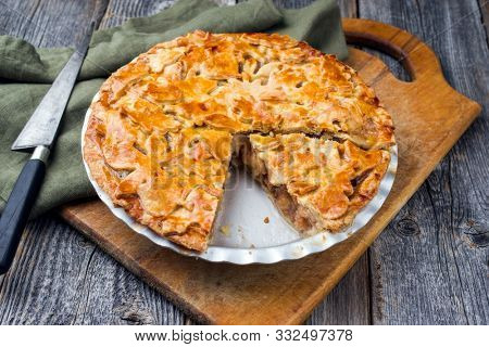 Traditional apple jalousie cake offered as closeup in a backing form on an old rustic wooden board 